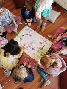 7 kids sharing a rainbow drawing activity 