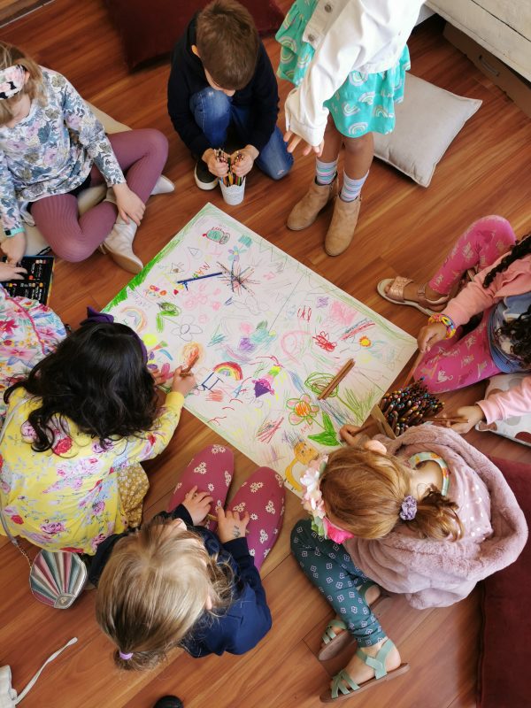 7 kids collaboratively drawing on floor